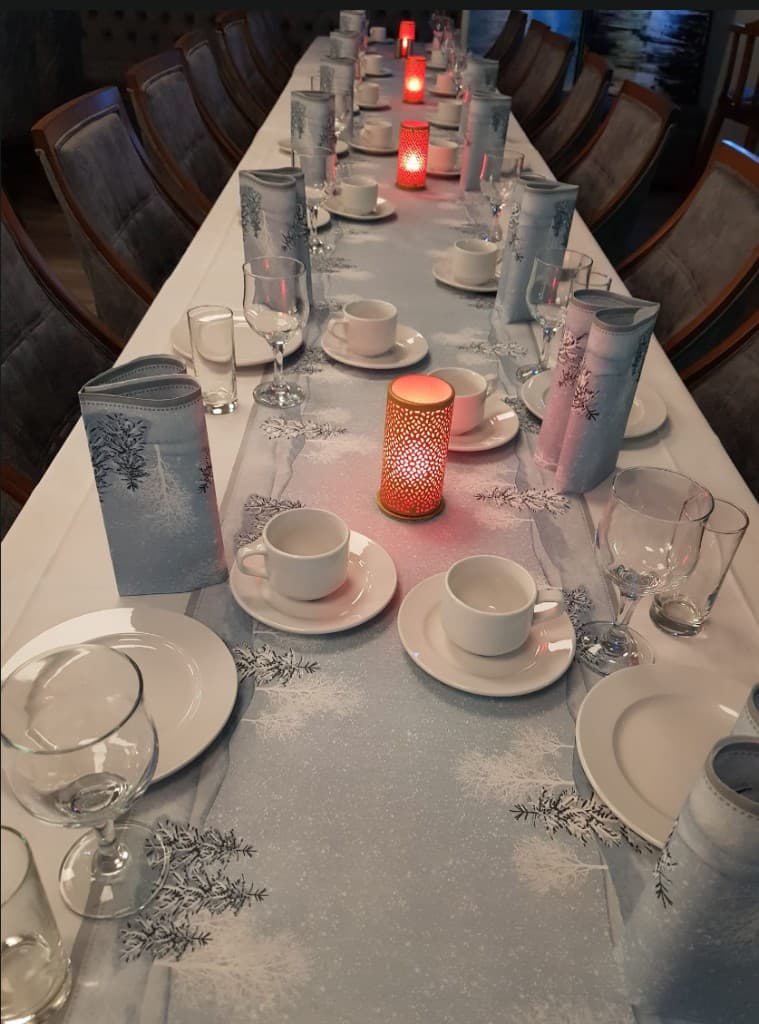 Langbord dekket til selskap med levende lys